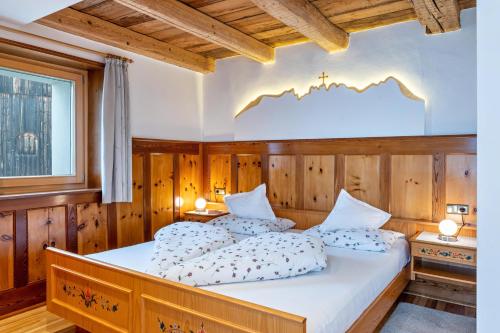 ein Schlafzimmer mit zwei Betten in einem Zimmer mit Holzwänden in der Unterkunft Grotthof in Deutschnofen