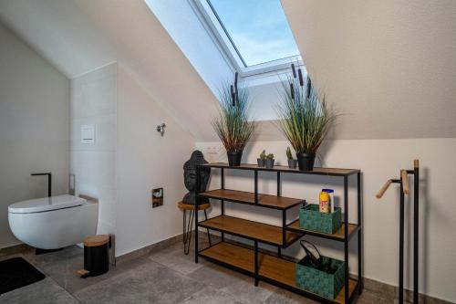 a bathroom with a toilet and a skylight at Haus Agatha in Wasserburg