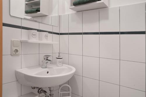 a bathroom with a sink and white tiled walls at Ferienhaus Kitzklause in Walkendorf
