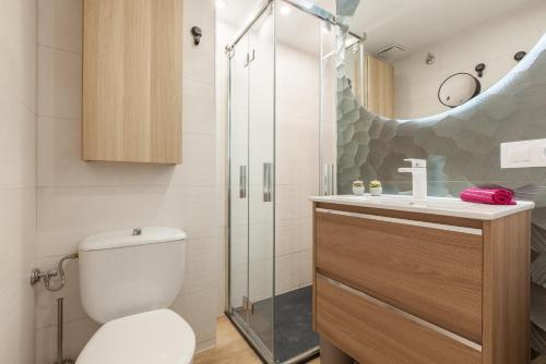a bathroom with a toilet and a glass shower at Fada Lloret in Lloret de Mar