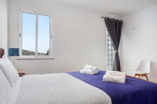 ein Schlafzimmer mit einem Bett, auf dem zwei Handtücher liegen in der Unterkunft Simão House in Calheta
