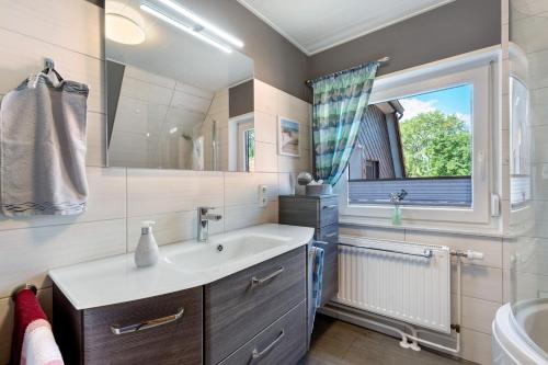 a bathroom with a sink and a window at Ferienwohnung Simonsen in Rabenkirchen-Faulück