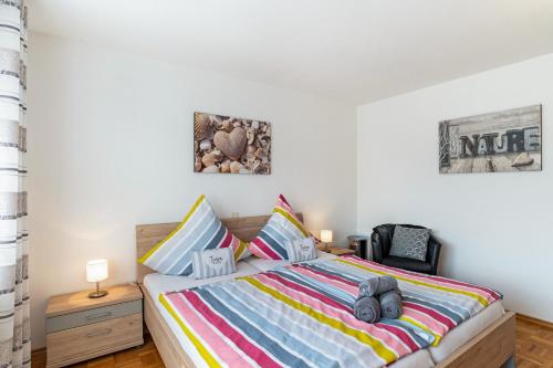 a bedroom with a bed with a colorful striped comforter at Ferienwohnung 'Kraichgau-Nest' in Reichartshausen
