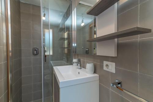 a bathroom with a white sink and a shower at House Punta Nera in Palau