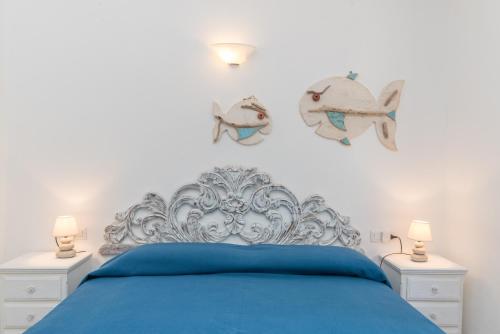 a bedroom with a blue bed with fish on the wall at House Punta Nera in Palau