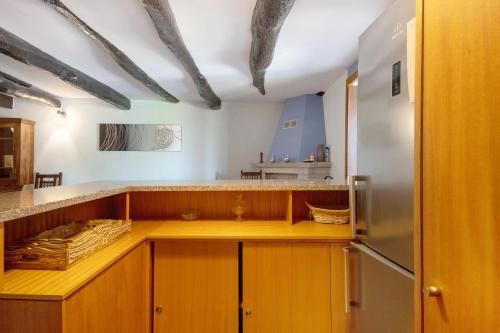 a kitchen with wooden cabinets and a refrigerator at Porto Douro - Maison in Foz do Sousa