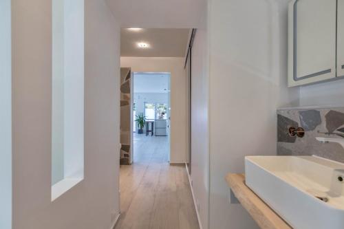 a white bathroom with a sink and a hallway at Wohnung Deluxe in Heide