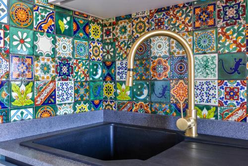 a kitchen with a sink and a colorful tile wall at Appartamento Thomas in Capoliveri