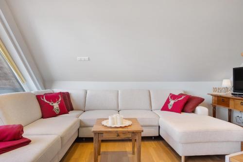 a living room with a white couch and red pillows at Ferienwohnung Hirschsprung Saig in Lenzkirch