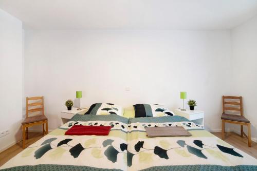 a bedroom with a large bed with two chairs at Ferienwohnung Leineufer in Friedland