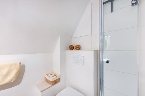 a white bathroom with a glass shower stall at Inselliebe in Pellworm