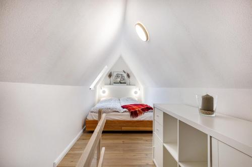 a small bedroom with a bed in a attic at Inselliebe in Pellworm