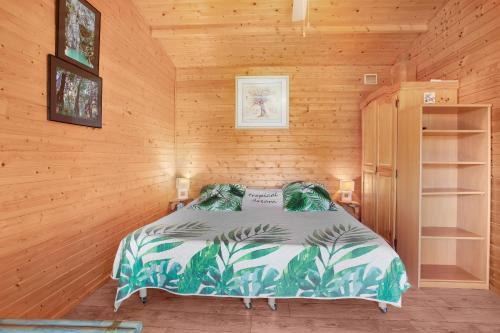 a bedroom with a bed in a wooden cabin at Joli Chalet en bois mésange bleu in Roquebrune-sur-Argens