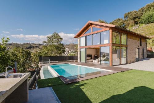 a house with a swimming pool in the yard at Dunas e Abraços in Braga