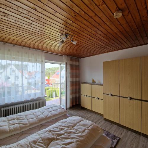 a bedroom with two beds and a large window at Ferienwohnung Mawitha in Roth