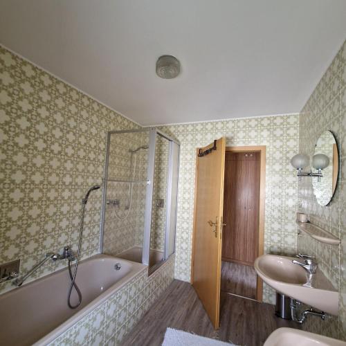 a bathroom with a bath tub and a sink at Ferienwohnung Mawitha in Roth