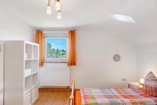 a bedroom with a bed and a window at Kreuzbergblick Bayerischer Wald in Hohenau