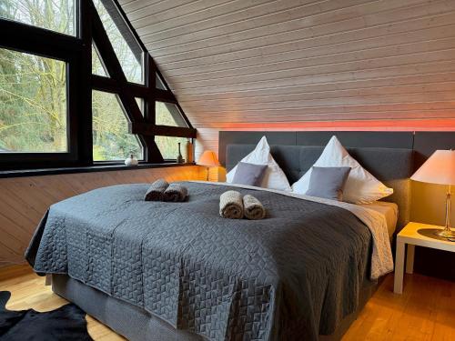 a bedroom with a bed with two slippers on it at Landhaus Bornemann in Diemelsee