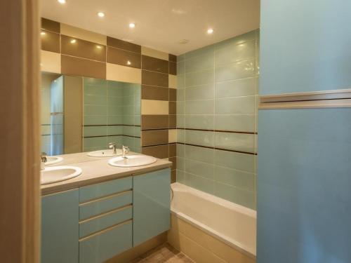 a bathroom with a sink and a mirror and a tub at Chalet Lova in Valloire