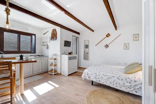 a white room with a bed and a kitchen at Casa Tajaraste 1 in Hermigua