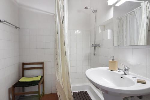 a white bathroom with a sink and a shower at Pedras Del Rei 8 in São Pedro