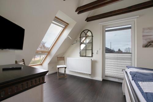a bedroom with a bed and a tv and a window at Ferienhaus Martje in Hennstedt