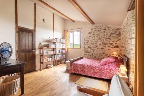 a bedroom with a bed and a book shelf at Mas Vizern avec bain nordique in Taillet