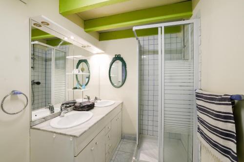 a bathroom with two sinks and a shower at Loft Atypique jacuzzi sauna in Cléguérec