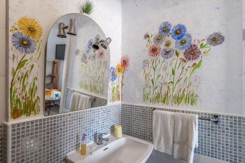 a bathroom with flowers painted on the wall at Aquedarte in Lisbon