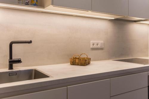 a kitchen counter with a sink and a basket at Mountain Meadows Apt 4 in Valdaora