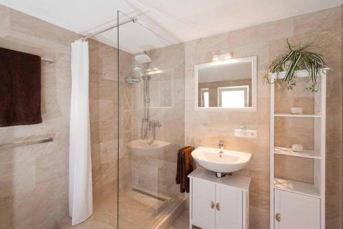 a bathroom with a sink and a glass shower at Haus Behr am See in Radolfzell am Bodensee