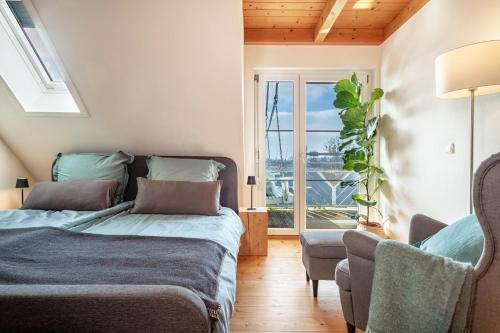 a bedroom with a bed and a window and a chair at Ferienwohnung Meckenbeuren in Meckenbeuren