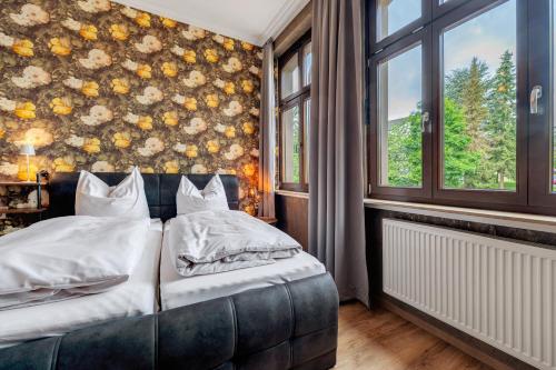 a bedroom with a bed and a floral wall at Gästezimmer St Wendel in Prüm