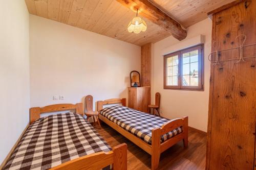 a bedroom with two beds and a window at Appartement Des Fontaines Albiez in Albiez-le-Jeune