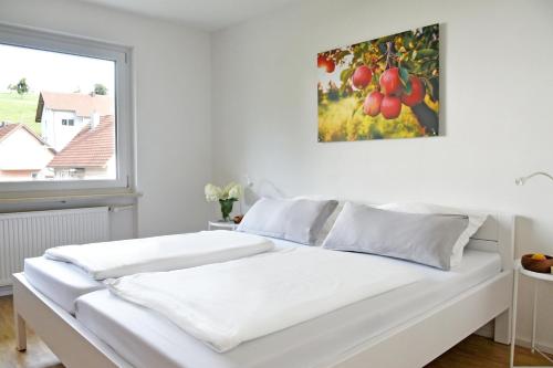 a white bed in a room with a painting on the wall at Quartier Wellant in Weißensberg