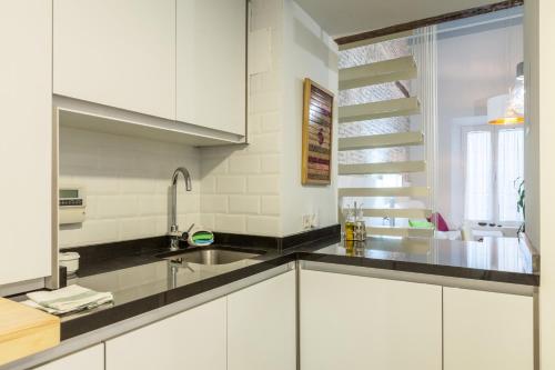 a kitchen with white cabinets and a sink at Orbyz in Seville