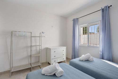 a white bedroom with two beds and a shower at Casa Camposoto in San Fernando