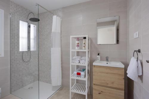 a white bathroom with a shower and a sink at Casa Camposoto in San Fernando