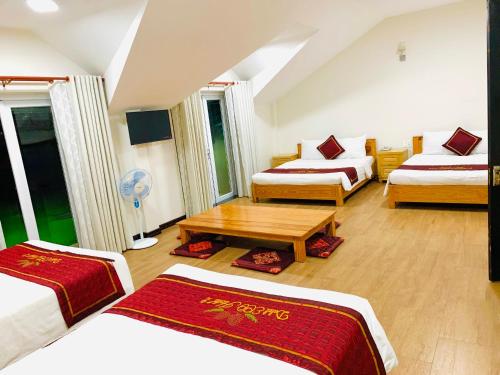 a hotel room with two beds and a table at Dalat ECO Hotel 2 in Da Lat