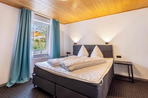 a bedroom with a bed with blue curtains and a window at Haus Fürstenberg Komplett in Fürstenberg