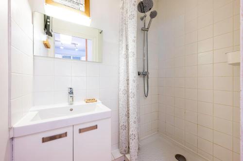a white bathroom with a sink and a shower at La maison d’Anthelmette in Valloire