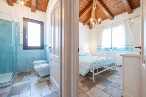 a bathroom with a bed and a shower and a toilet at Villa Tramonto in Villasimius