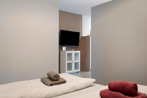 a room with a bed with two towels and a television at Kornblume in Unterwittighausen