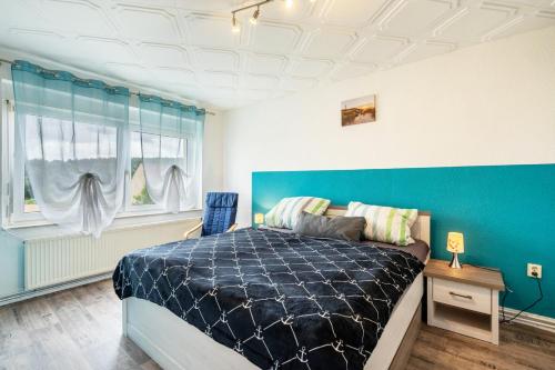 a bedroom with a bed and a blue wall at Familie Heiko Schroth in Neußen