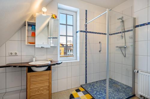 a bathroom with a sink and a shower at Haus Übersee Wohnung Tonga in Travemünde