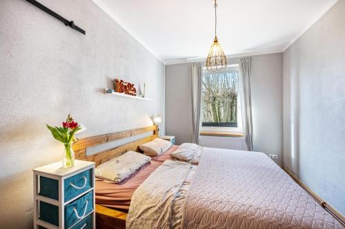 a bedroom with a bed and a vase of flowers at Koogbutze in Wesselburenerkoog