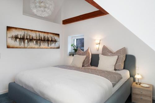 a bedroom with a large white bed with pillows at Ferienwohnungen Steiert in Freiburg im Breisgau
