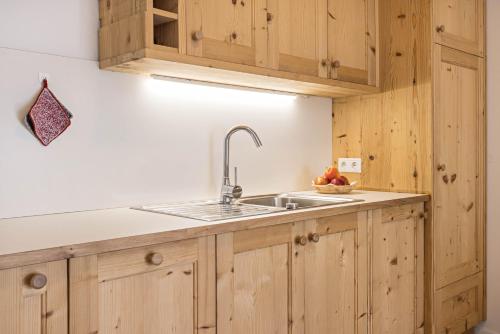 a kitchen with a sink and wooden cabinets at Ciasa Silvia in San Martino in Badia