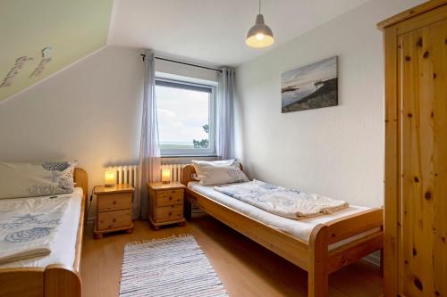 a bedroom with two beds and a window at Gästehaus Tadenswarf in Tadenswarf