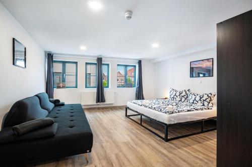ein Wohnzimmer mit einem Bett und einer Couch in der Unterkunft Jever Auszeit in Jever